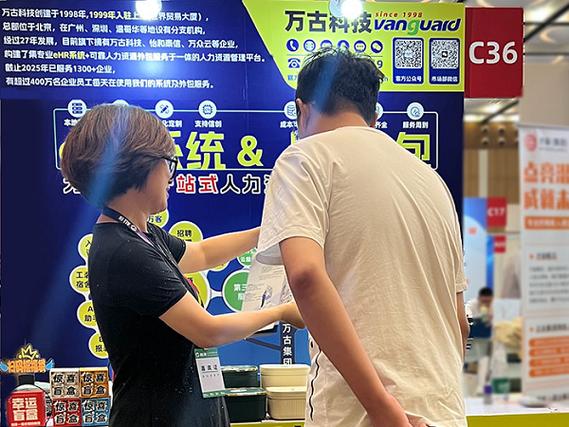 代表演示hr軟件系統(tǒng)的功能,旁邊還站著幾位人員在咨詢?nèi)肆ν獍?wù)